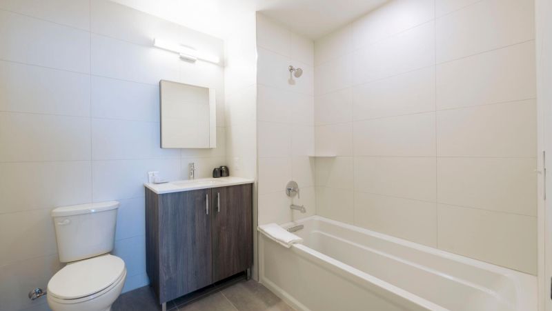 A clean bathroom with a toilet, sink, and bathtub