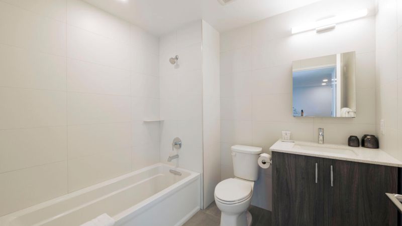 A modern bathroom with a bathtub, toilet, and sink